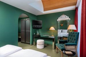 a bedroom with green walls and a bed and a desk at Wyndham Garden Donaueschingen in Donaueschingen
