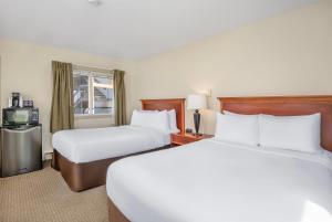 a hotel room with two beds and a television at Travelodge by Wyndham Gananoque in Gananoque +18 photos