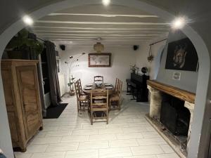 een eetkamer met een tafel en stoelen en een open haard bij Sous le chemin de Paris in Milly-la-Forêt
