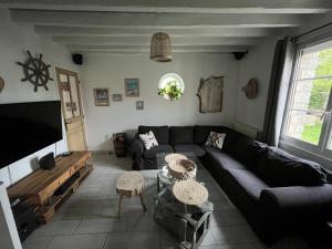 een woonkamer met een bank en een flatscreen-tv bij Sous le chemin de Paris in Milly-la-Forêt