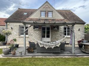 een huis met een houten terras met een tuinhuisje bij Sous le chemin de Paris in Milly-la-Forêt