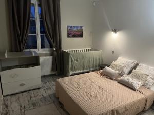 een slaapkamer met een bed, een ladekast en een raam bij Sous le chemin de Paris in Milly-la-Forêt