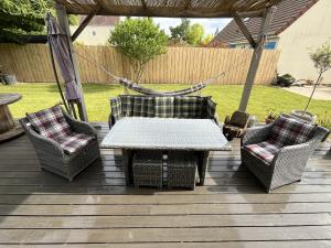 een patio met een tafel, 2 stoelen en een hangmat bij Sous le chemin de Paris in Milly-la-Forêt +3 foto's