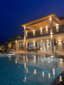 a large house with a swimming pool at night at Royal Tiki Lodges - Maison d'hôtes avec Piscine chauffée & SPA in Plaissan