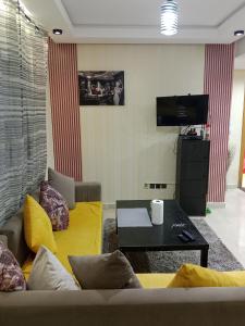 una sala de estar con un sofá y una mesa en Résidence journalière chic Casablanca, en Casablanca