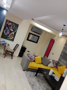 Una sala de estar con un sofá amarillo y una mesa. en Résidence journalière chic Casablanca, en Casablanca