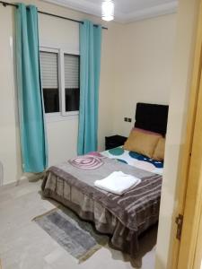 Un dormitorio con una cama con cortinas azules. en Résidence journalière chic Casablanca, en Casablanca