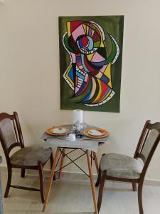 una mesa con dos sillas y un cuadro en la pared en Résidence journalière chic Casablanca, en Casablanca