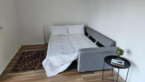 a bed in a small room with a side table at Modern apartment with sea views in Vlorë