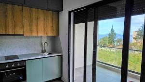 a kitchen with a large window with a view at Modern apartment with sea views in Vlorë