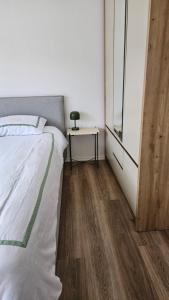 a bedroom with a bed and a table with a lamp at Modern apartment with sea views in Vlorë +1 photo