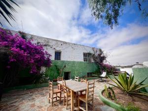 una mesa de madera y sillas frente a un edificio en Casa Gatti - Autentica Casa Canaria nel cuore di Lanzarote, en Tiagua