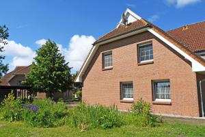 a brick house with a tree in the yard at schöne 3-Raum-Ferienwohnung direkt im Nationalpark in Ummanz