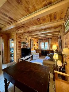 salon z drewnianym sufitem i stołem w obiekcie Hotel Letterario Locanda Collomb w mieście La Thuile