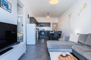 a living room with a couch and a kitchen at Olympus 2-Bedroom Apartment in Larnaca
