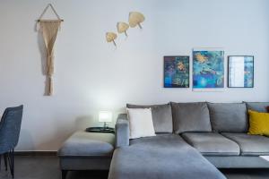 a living room with a gray couch and pictures on the wall at Olympus 2-Bedroom Apartment in Larnaca