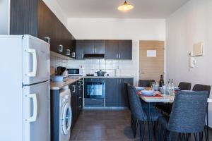 a kitchen with a table with chairs and a refrigerator at Olympus 2-Bedroom Apartment in Larnaca