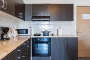 a kitchen with a black oven and a microwave at Olympus 2-Bedroom Apartment in Larnaca +9 photos