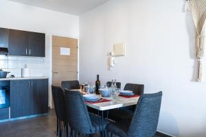 a dining room table with chairs and a bottle of wine at Olympus 2-Bedroom Apartment in Larnaca