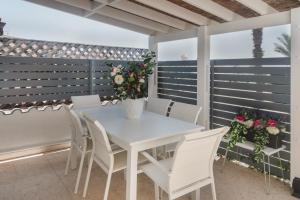 a white table and chairs on a balcony with flowers at Botanical Art House by Staycom in Paphos City +6 photos