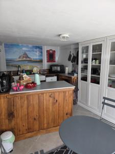 a kitchen with wooden cabinets and a counter top at Les Petits Champs in Buais