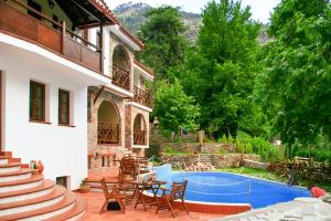 a patio with a table and chairs next to a house at Kazaviti Luxury Suites in Mikrós Prínos