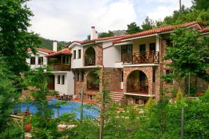 an exterior view of a house with a swimming pool at Kazaviti Luxury Suites in Mikrós Prínos