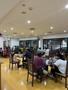 a group of people sitting at tables in a restaurant at HOTEL DWARA in Subrahmanya