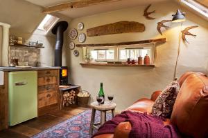 a living room with a couch and a table with wine glasses at The Barley Mill in Bude