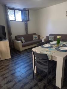 una sala de estar con una mesa y un sofá en La Perla Marina, en Quartu SantʼElena