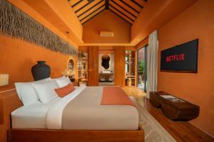スミニャックにあるSana Vie Villa Seminyak by Ini Vie Hospitalityの大きなベッドとテレビのある寝室 +29枚の写真