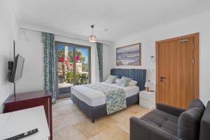 a bedroom with a bed and a tv and a couch at Bal Butik Otel in Datca