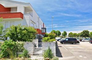 a building with cars parked in a parking lot at SOFIA house with apartment in Umag