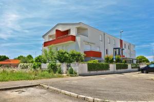 a white and red building with a parking lot at SOFIA house with apartment in Umag