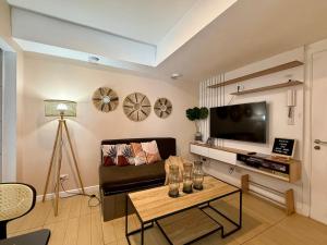 a living room with a couch and a tv at The Bahamas & Maldives Suites at Azure Residences near Manila Airport in Manila