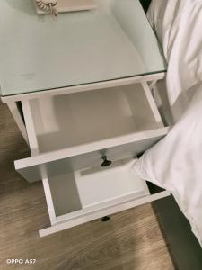 a white bedside table with a drawer at Richico Hotel in Ho Chi Minh City