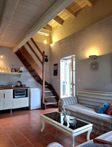 a living room with a couch and a staircase at Aga's Seaview Cottages in Ágios Márkos