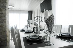 a dining room table with plates and wine glasses at Villa Terveenniemi in Kontula +27 photos