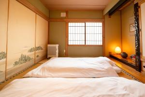 a bedroom with two beds and a window at FIKA - Komorebi in Furano