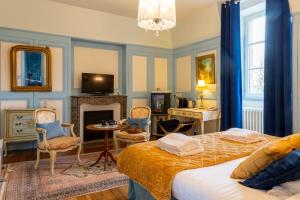 a bedroom with a bed and a table and chairs at Château Hôtel Du Colombier in Saint Malo