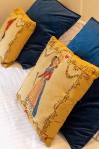 a blanket with a woman on a bed with pillows at Château Hôtel Du Colombier in Saint Malo +54 photos
