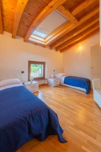 two beds in a room with wooden ceilings at Villa Belvedere in Settimo