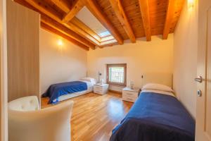 two beds in a room with wooden ceilings at Villa Belvedere in Settimo