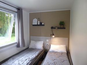 ピリアック・シュル・メールにあるVacances en Mobil home à Piriac sur merのベッドと窓のある小さな部屋