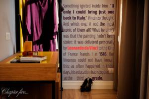 a curtain in a room with a table and a dresser at The Frame Hotel in Florence