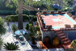 einen Hinterhof mit einem Pool und einer Terrasse mit Pflanzen in der Unterkunft La Cicas in Anacapri