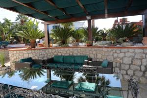 a patio with a couch and chairs and plants at La Cicas in Anacapri