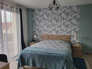Un dormitorio con una cama con un edredón azul. en Chambres d'hôtes dans maison contemporaine, en Vernouillet