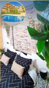 łóżko z poduszkami przed ścianą z cegły w obiekcie Apartamento Las 3P Piscina, Paz y Patio privado w mieście Fuengirola