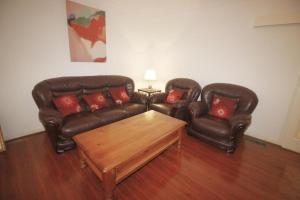 two leather couches and a coffee table in a living room at Garden Guesthouse - Melbourne Airport Accommodation in Melbourne +17 photos